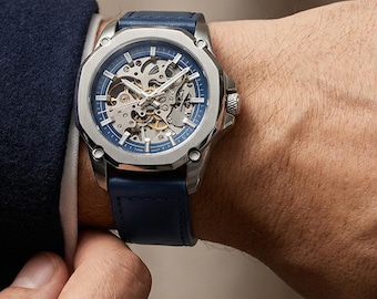 Reloj mecánico esquelético para hombre con correa de cuero y manecillas luminosas.