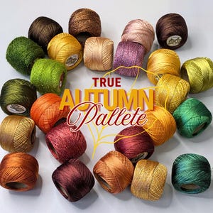 May include: A collection of twenty-four small, round balls of metallic embroidery thread in various autumn-inspired colours including shades of green, gold, orange, red, brown, and purple. The text TRUE AUTUMN Pallete is centred in the middle.