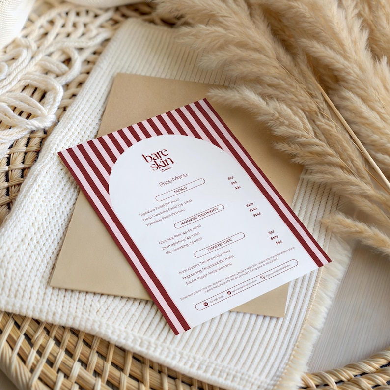 May include: A price menu from "Bare Skin Studio" with a white background and red stripes. The menu lists facials, advanced treatments, and targeted care options. The menu is on a tan envelope, atop a white knitted blanket and dried plants.
