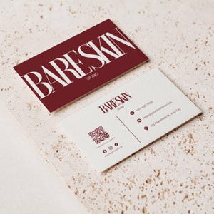 May include: Two business cards with the text "BARESKIN STUDIO". One card is burgundy with white text, the other is off-white with burgundy text. The off-white card includes a QR code, phone number, email, and address.