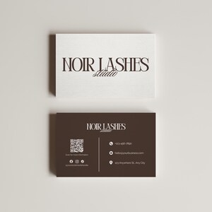May include: Two business cards with the text "NOIR LASHES Studio". The top card is white, and the bottom card is dark brown. The bottom card includes a QR code, social media icons, a phone number, an email address, and a physical address.