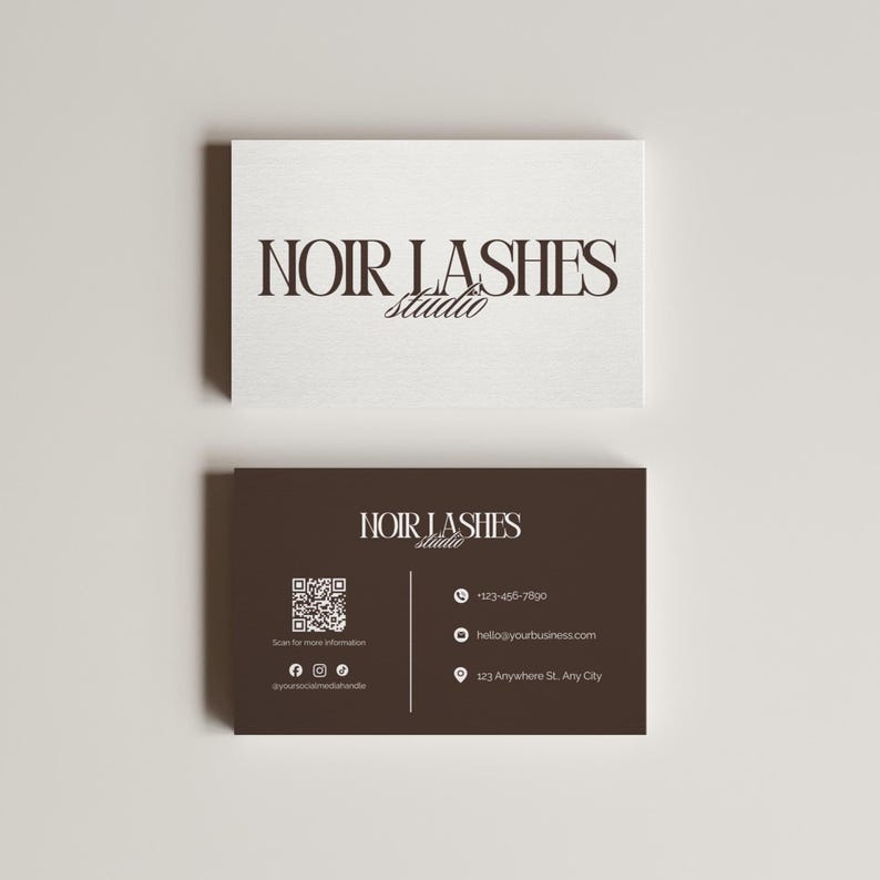 May include: Two business cards with the text "NOIR LASHES Studio". The top card is white, and the bottom card is dark brown. The bottom card includes a QR code, social media icons, a phone number, an email address, and a physical address.