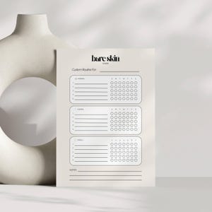 Peut inclure: Un planificateur de routine de soins de la peau beige avec le texte "bare skin studio" en haut. Le planificateur comprend des sections pour les routines du matin, du soir et hebdomadaires, avec des cases &agrave; cocher pour le suivi. Le planificateur est con&ccedil;u pour personnaliser les soins de la peau.