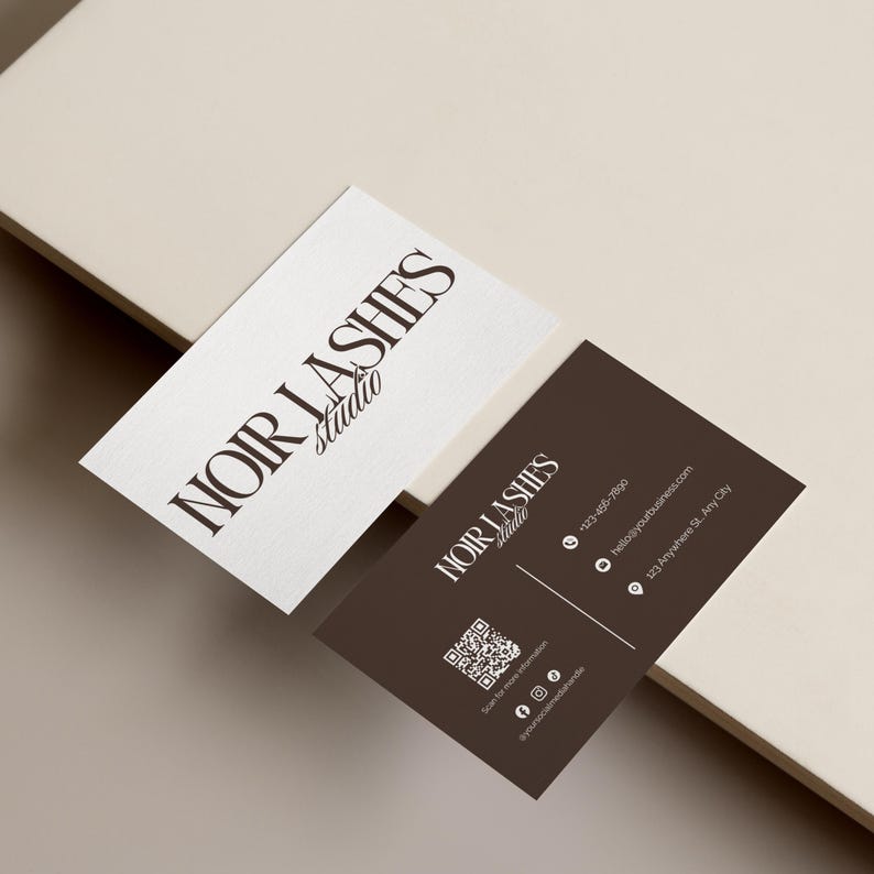 May include: Two business cards with the text "NOIR LASHES Studio". One card is white with dark brown text, the other is dark brown with white text. The dark brown card includes a QR code and contact information.