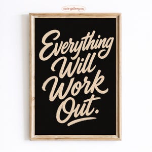 May include: A framed wall art print featuring a black background with the text Everything Will Work Out written in a light beige, brush-style script font. The frame is made of light-colored wood with a natural grain finish and simple edges.