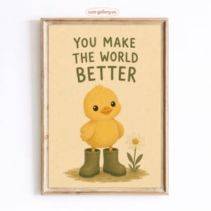 May include: A framed wall art print featuring a yellow chick wearing olive green rain boots, standing next to a white daisy. The text above the chick reads, "YOU MAKE THE WORLD BETTER" in dark green, sans-serif capital letters on a light tan background.
