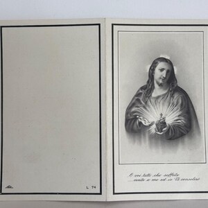 Pode incluir: Um cartão religioso vintage aberto, apresentando uma ilustração em preto e branco de Jesus segurando um coração brilhante. O cartão tem uma borda preta e texto italiano na parte inferior. O lado esquerdo está em branco com uma borda preta e o número "L 74".