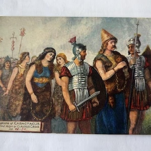 Puede incluir: Postal antigua que representa la captura de Carataco, con figuras vestidas a la romana y celta. La ilustración muestra un grupo de personas, incluyendo soldados con espadas y escudos, y mujeres con ropas drapeadas. El texto en la parte inferior dice "Capture of Caractacus...AD 42-54."
