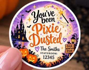 Puede incluir: Una pegatina circular con temática de Halloween en morado y naranja que muestra la silueta de un castillo, calabazas, murciélagos y una varita mágica. El texto dice You've been Pixie Dusted, The Smiths, STATEROOM: 12345 y Trick or Treat.