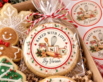 May include: A round sugar cookie in a clear plastic bag tied with red and white twine. The cookie features a printed label with the text BAKED WITH LOVE By Vivian, showing illustrations of a whisk, rolling pin, jar, and gingerbread man.