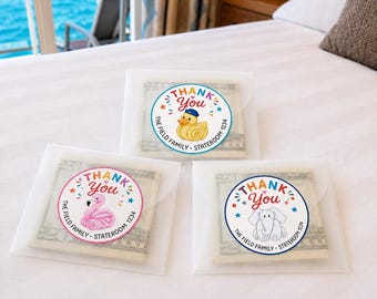 May include: Three translucent envelopes containing folded US currency, each sealed with a circular sticker. The stickers feature the text THANK YOU, The Field Family, Stateroom 1234, and illustrations of a yellow duck, a pink flamingo, or an elephant.