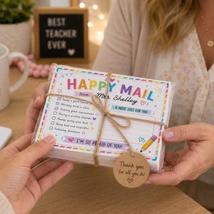Könnte beinhalten: Ein Stapel rechteckiger Notizkarten mit der Aufschrift HAPPY MAIL from Mrs. Shelley, einer Checkliste für positive Bestätigungen, einer Bleistiftgrafik und einem braunen runden Anhänger mit der Aufschrift Thank you for all you do und Herz.