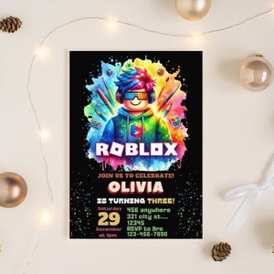 May include: A black invitation card with a colorful Roblox theme. The card features a Roblox character with headphones and glasses, surrounded by paint splatters. Text includes "ROBLOX", "OLIVIA IS TURNING THREE!", date, time, and RSVP information.