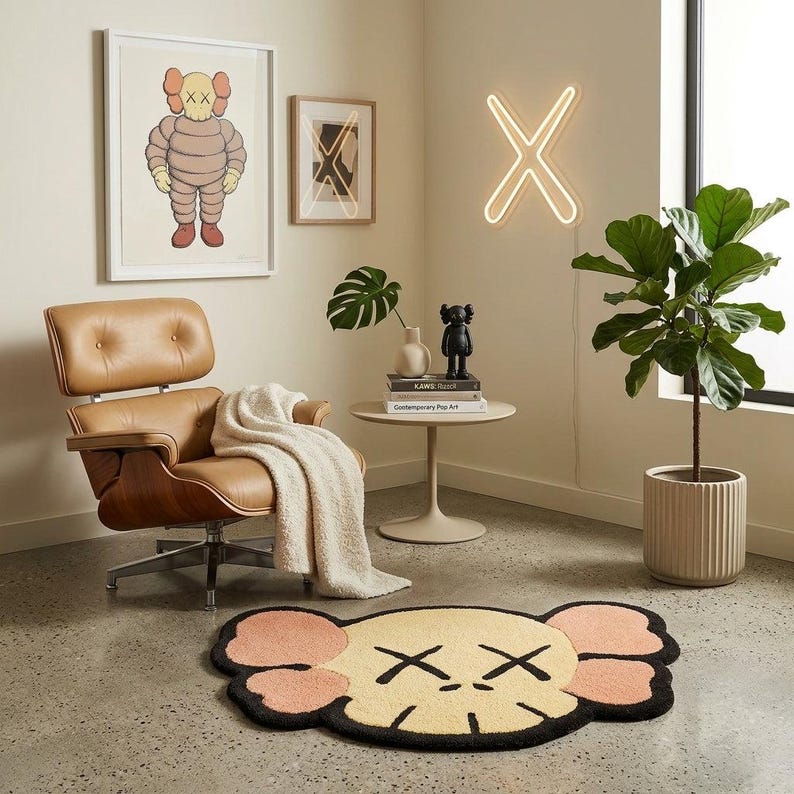Puede incluir: Un sill&oacute;n de cuero beige con una manta blanca, una mesa redonda con libros y una figura negra, una luz de ne&oacute;n en forma de X, dos cuadros, una planta en maceta y una alfombra beige con forma de cabeza de personaje con ojos en forma de X.