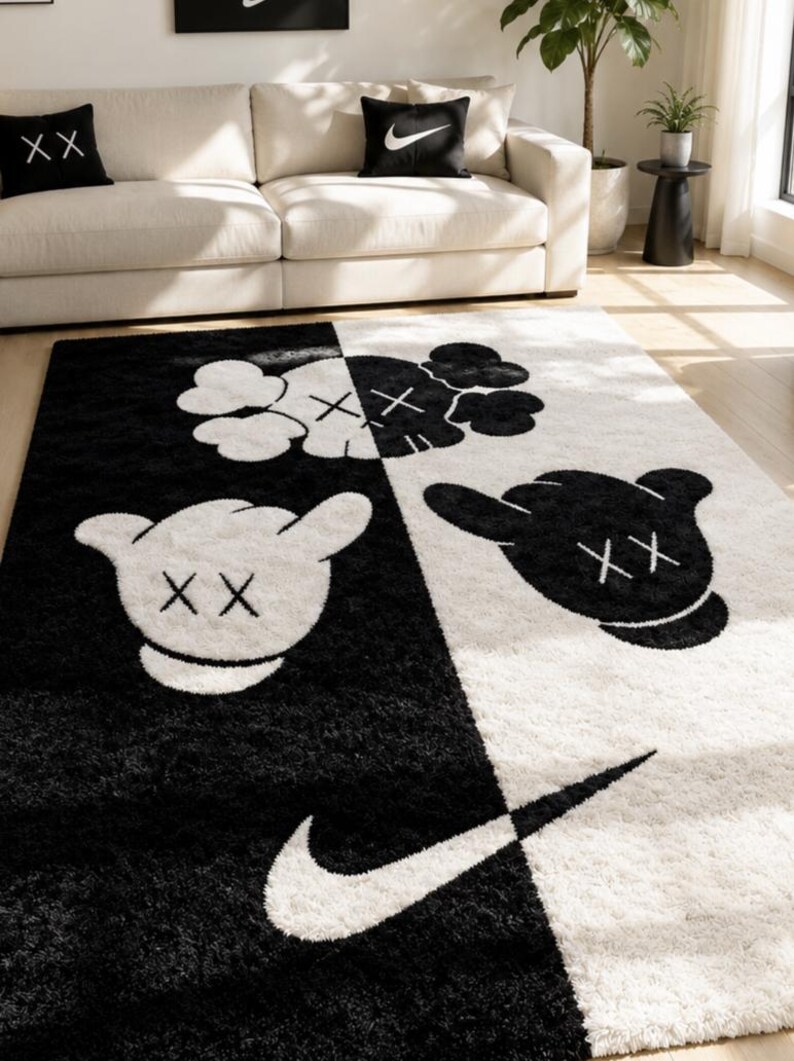 May include: A rectangular area rug featuring a split black and white design. The rug displays cartoon-style gloved hands with 'XX' eyes and a large Nike swoosh logo. The pattern is divided diagonally, with white graphics on the black side and black graphics on the white side, creating a high-contrast visual effect.