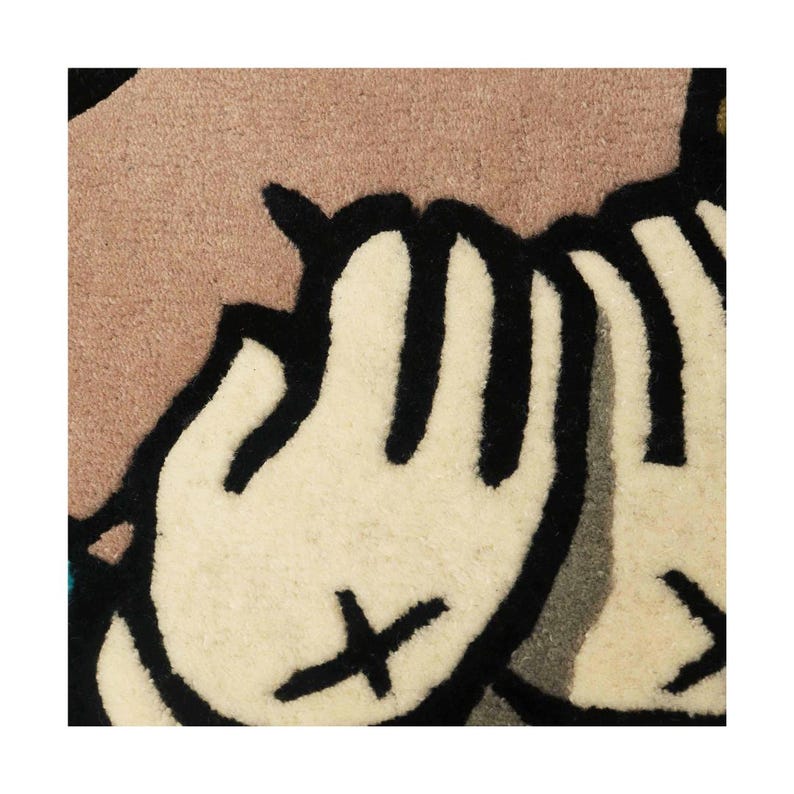 Puede incluir: Una alfombra de mechones con un dise&ntilde;o gr&aacute;fico de dos manos de color crema con contornos negros y s&iacute;mbolos X negros en las palmas. Las manos est&aacute;n colocadas sobre un fondo malva apagado, con gruesos bordes negros que definen las formas y detalles.