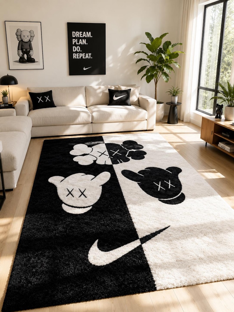 May include: A rectangular area rug featuring a split black and white design. The rug displays stylized cartoon character heads with X-shaped eyes and gloved hand motifs, along with a prominent white Nike swoosh logo positioned on the black section.