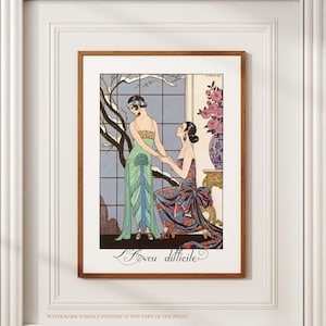 May include: A framed art print featuring an Art Deco illustration. Two women are depicted in elegant gowns, one in green and the other in a patterned dress. The artwork includes a window with a winter scene and the French text "L'Amour difficile".