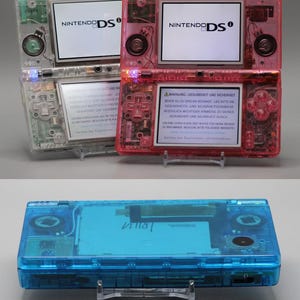 Nintendo DSi ∗ Porta USB-C ∗ Carcaça transparente ∗ Nova tela sensível ao toque ∗ Nova bateria maior ∗ Estojo de transporte