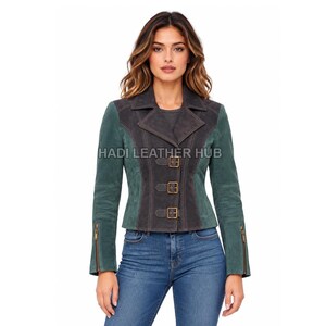 Könnte beinhalten: Eine zweifarbige Wildlederjacke mit dunkelgrauen Einsätzen an der Vorderseite und am Kragen, kontrastiert durch waldgrüne Ärmel und Seitenteile. Die Jacke verfügt über drei Schnallenverschlüsse, Reißverschlüsse an den Ärmeln und den Text HADI LEATHER HUB.