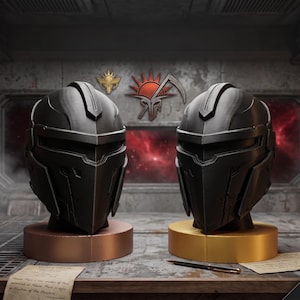 May include: Two matte black helmets with angular, futuristic designs, each mounted on a circular base. The left helmet sits on a copper-colored base, while the right helmet sits on a gold-colored base. A red sun and scythe emblem is visible behind them.