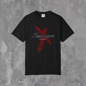 Peut inclure: T-shirt noir avec le mot "Xenogears" dans une police stylisée et un graphique "X" rouge. Le t-shirt comprend également du texte japonais sous le titre principal. Un tee-shirt décontracté à manches courtes.