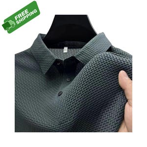 Pode incluir: Camisa cinza escuro com gola e um padr&atilde;o de tecido texturizado. A camisa tem uma frente abotoada e uma gola cl&aacute;ssica. O tecido parece macio e flex&iacute;vel. A imagem inclui um adesivo verde "FREE SHIPPING" no canto superior esquerdo.