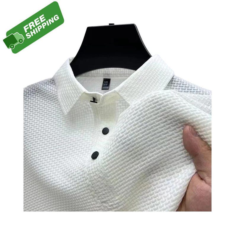 Pode incluir: Camisa branca texturizada com bot&otilde;es pretos e gola cl&aacute;ssica. A camisa tem um padr&atilde;o tecido e &eacute; exibida em um cabide preto. A imagem inclui um adesivo verde "FRETE GR&Aacute;TIS".