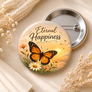 May include: A round button with a butterfly design and the words "Eternal Happiness". The butterfly is orange and black, with a sunset background. The button has a metal pin back.