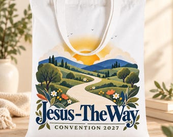 May include: A white canvas tote bag featuring a colorful graphic of a winding path through rolling green hills, trees, and a bright yellow sun. The text "Jesus-The Way" is printed in large dark blue letters, with "CONVENTION 2027" below it.