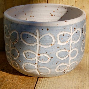 May include: A set of three ceramic mugs with a speckled, matte finish in cream, light grey, and dark grey. Each mug has a simple, minimalist design and a rounded handle.