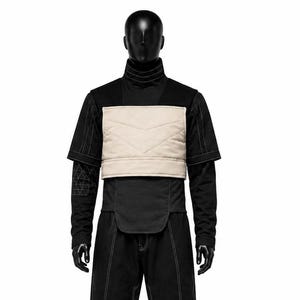 May include: A black high-neck short-sleeve shirt with white contrast stitching, featuring a beige quilted chest panel. The outfit includes matching black trousers with white contrast stitching and rectangular knee detailing, displayed on a mannequin.