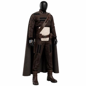 May include: A dark brown costume set featuring a long cape, a long-sleeved top with black horizontal stripes, and matching trousers. The outfit includes a cream-colored waist panel, a brown utility belt with pouches, and brown buckled boots.