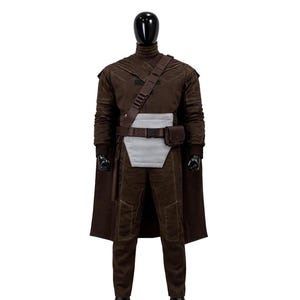 May include: A dark brown costume set on a mannequin, featuring a long-sleeved top, matching trousers, and a cape. The outfit includes a light gray rectangular abdominal panel, a dark brown utility belt with a pouch, and a diagonal shoulder strap.