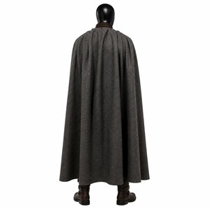 May include: A floor-length charcoal gray wool cape featuring a dark brown leather collar. The cape is draped over a black mannequin head and shoulders, paired with dark brown leather boots that have side buckle closures and a low heel.
