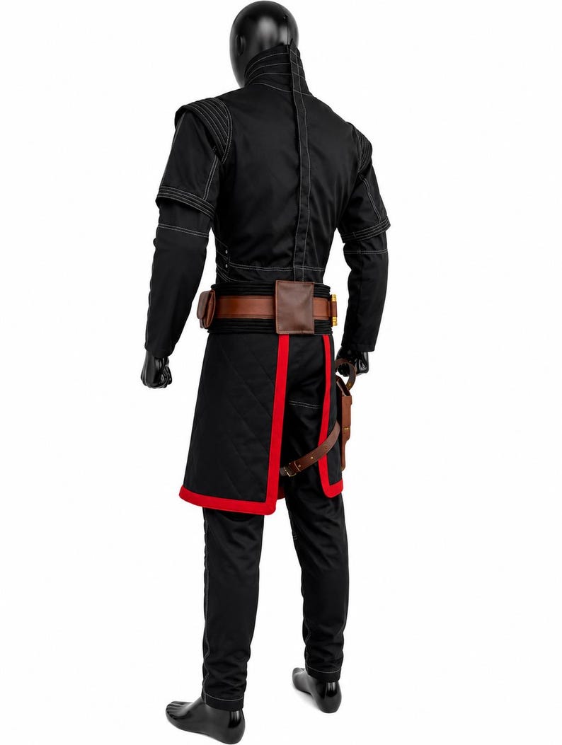 May include: A black costume featuring a high-collared jacket with white stitching, a brown leather utility belt with pouches, and a black quilted tunic with red trim. The outfit includes black trousers and black gloves, worn by a mannequin.
