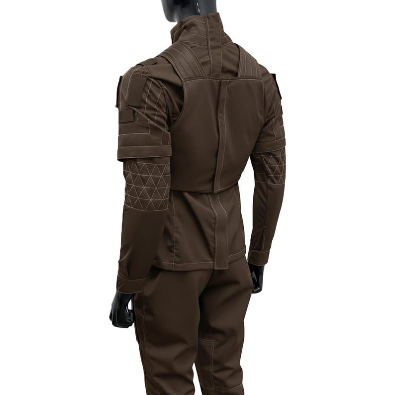 Pu&ograve; includere: Un completo composto da giacca e pantaloni in stile tattico color marrone scuro. La giacca presenta un colletto alto, pannelli strutturati sulle spalle e un motivo geometrico a triangoli cuciti sugli avambracci. Il capo presenta cuciture chiare visibili.