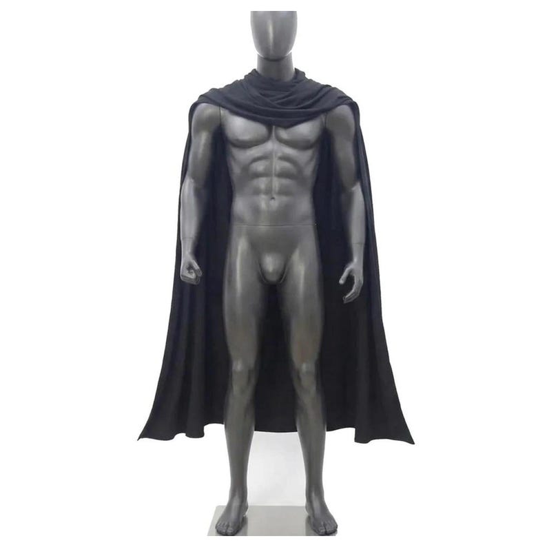 May include: A solid black cape featuring a draped cowl neckline that rests around the shoulders. The garment is displayed on a dark gray, muscular, featureless mannequin, extending down to the lower legs with a smooth, flowing fabric drape.