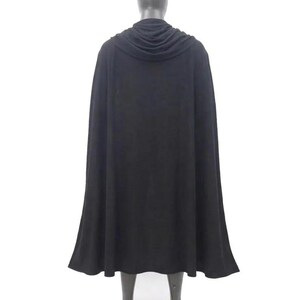 May include: A solid black floor-length cape featuring a draped cowl neckline that rests around the shoulders. The garment is displayed on a neutral-toned mannequin, showcasing a full-length silhouette with a smooth, flowing fabric texture.