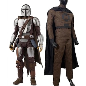 May include: A silver and brown armored action figure with a helmet and cape stands next to a mannequin wearing a brown long-sleeved shirt with black rectangular patches, brown trousers, a black cape, and a black helmet covering the head.