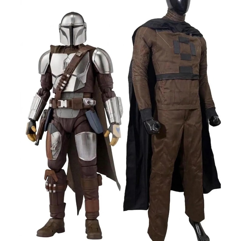 May include: A silver and brown armored action figure with a helmet and cape stands next to a mannequin wearing a brown long-sleeved shirt with black rectangular patches, brown trousers, a black cape, and a black helmet covering the head.