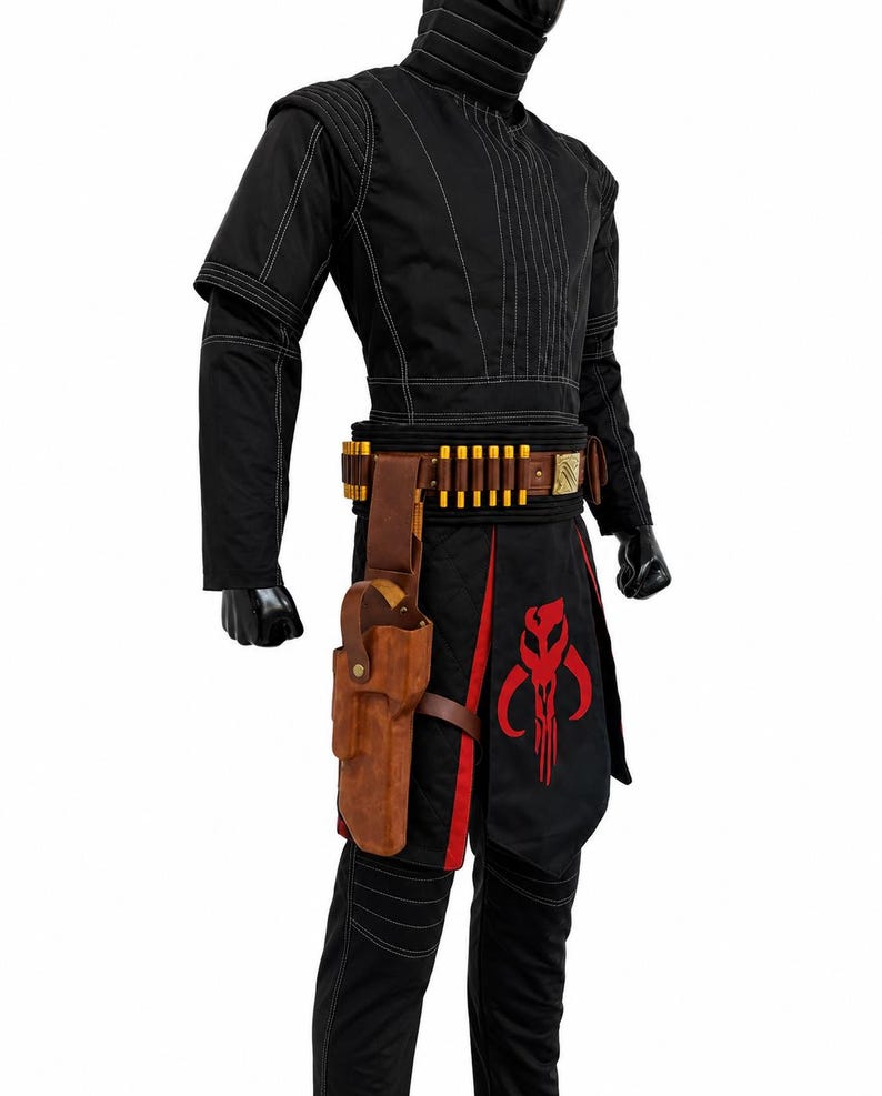May include: A black long-sleeved tunic and pants set featuring white stitching, a brown leather belt with gold-colored ammunition loops, a matching brown leather holster, and a black apron panel displaying a large red skull-shaped emblem.
