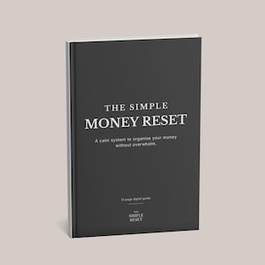 Könnte beinhalten: Ein Buch mit schwarzem Einband und weißem Text. Der Titel lautet "THE SIMPLE MONEY RESET", darunter der Untertitel: "A calm system to organise your money without overwhelm." Es ist ein digitaler Ratgeber.
