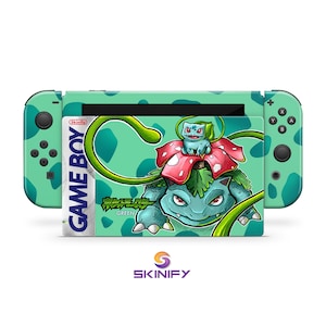 May include: A Nintendo Switch console with a custom skin featuring a Pokémon theme. The skin showcases a green and red Venusaur design with the text "GAME BOY" and Japanese text. The Joy-Con controllers are green with a polka dot pattern.