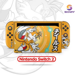 May include: A yellow Nintendo Switch 2 console with a custom skin featuring the character Tails from the Sonic the Hedgehog series. The skin has a vibrant orange and yellow background with Japanese text and the character Tails.