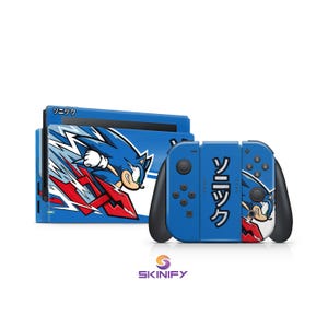 Puede incluir: Consola y mandos Nintendo Switch azules con un diseño de Sonic the Hedgehog. La consola presenta un gráfico de Sonic corriendo con detalles en rojo y blanco. Los mandos tienen el texto japonés "Sonic" y un gráfico de Sonic.