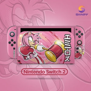 May include: A pink Nintendo Switch 2 console skin featuring a graphic of Amy Rose holding a large hammer. The design includes Japanese text, a circular pattern, and the Skinify logo in the corner. The console controllers are also pink with matching character artwork.