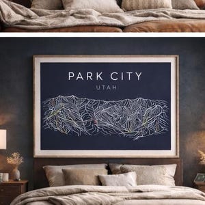 Könnte beinhalten: Ein gerahmter Druck mit dem weißen Schriftzug "PARK CITY UTAH". Der Druck zeigt eine detaillierte weiße Strichzeichnung eines Gebirges auf dunkelblauem Hintergrund. Der Rahmen ist hellbraun.