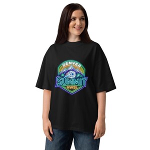 Könnte beinhalten: Schwarzes T-Shirt mit einem farbenfrohen Denver Summit NWSL-Logo. Das Logo zeigt einen Fußball, Berge und den Text "DENVER SUMMIT" und "NWSL" in einem Neon-Stil. Das T-Shirt hat eine lockere Passform.