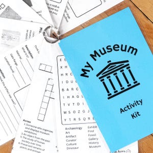 Puede incluir: Un folleto azul "My Museum Activity Kit" con una ilustración negra de un edificio se muestra con hojas de actividades. Las hojas incluyen preguntas para completar, un crucigrama y una búsqueda de palabras. El kit se mantiene unido con un anillo de metal.